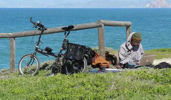 Mann mit einem Laptop am See