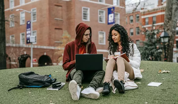 Studierende mit Notebook vor der Universität